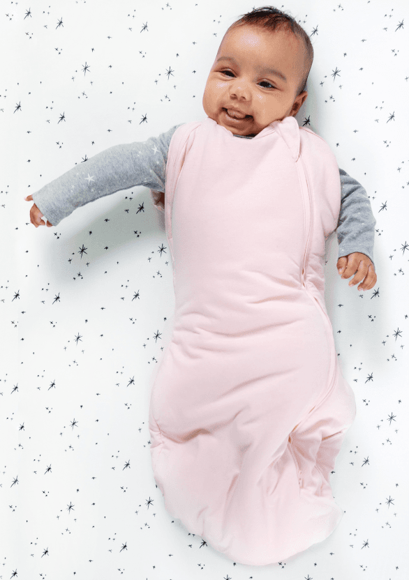 Bebis i sovpåse med armarna ut