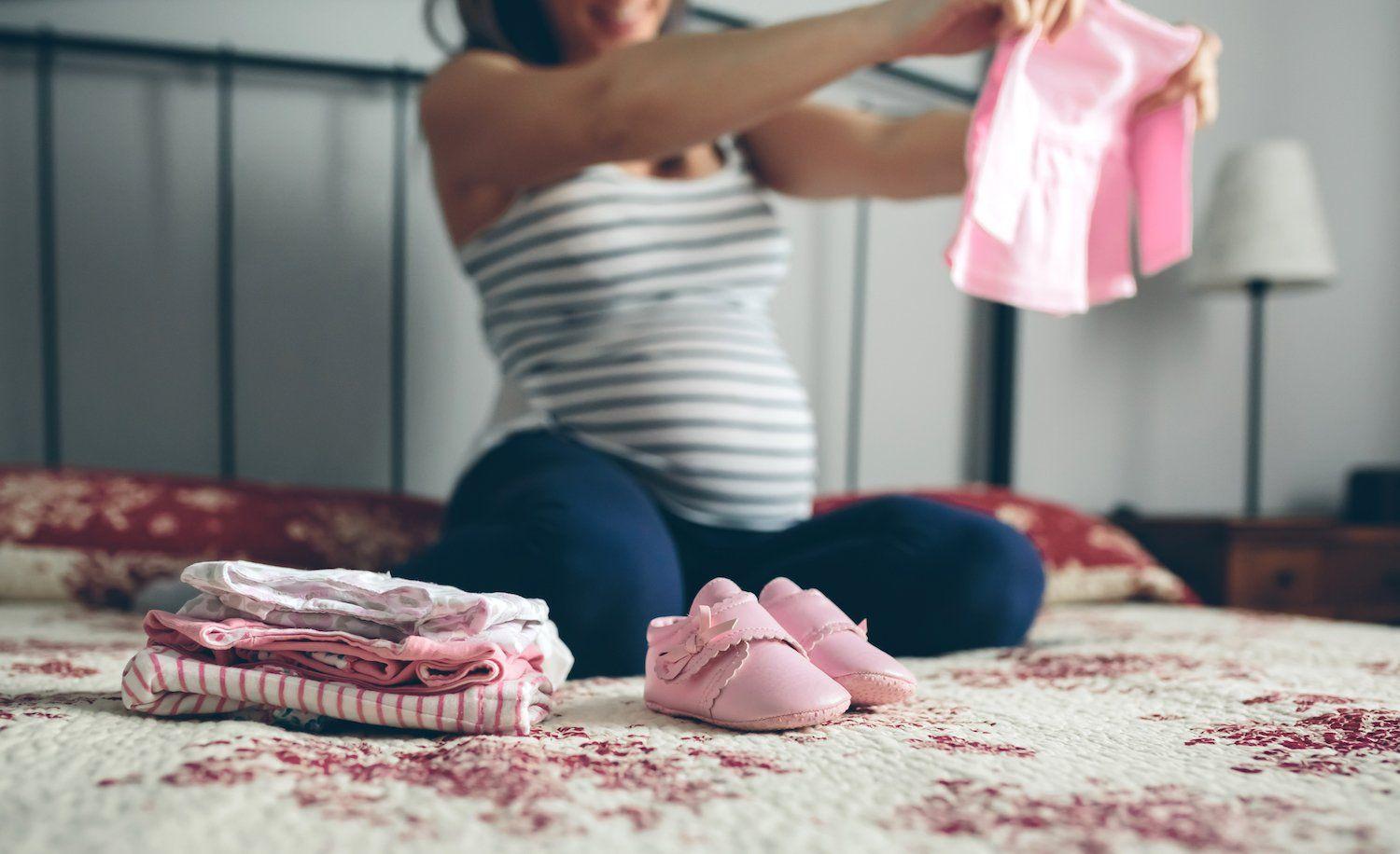 pregnant-mom-packing-baby-clothes-for-hospital