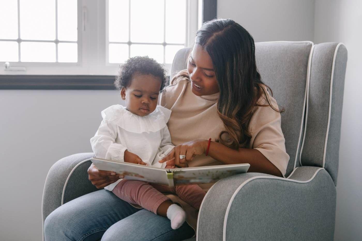 Mother reading to baby girl on lap