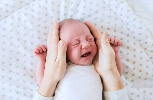 Får magsaftsreflux min bebis att gråta?